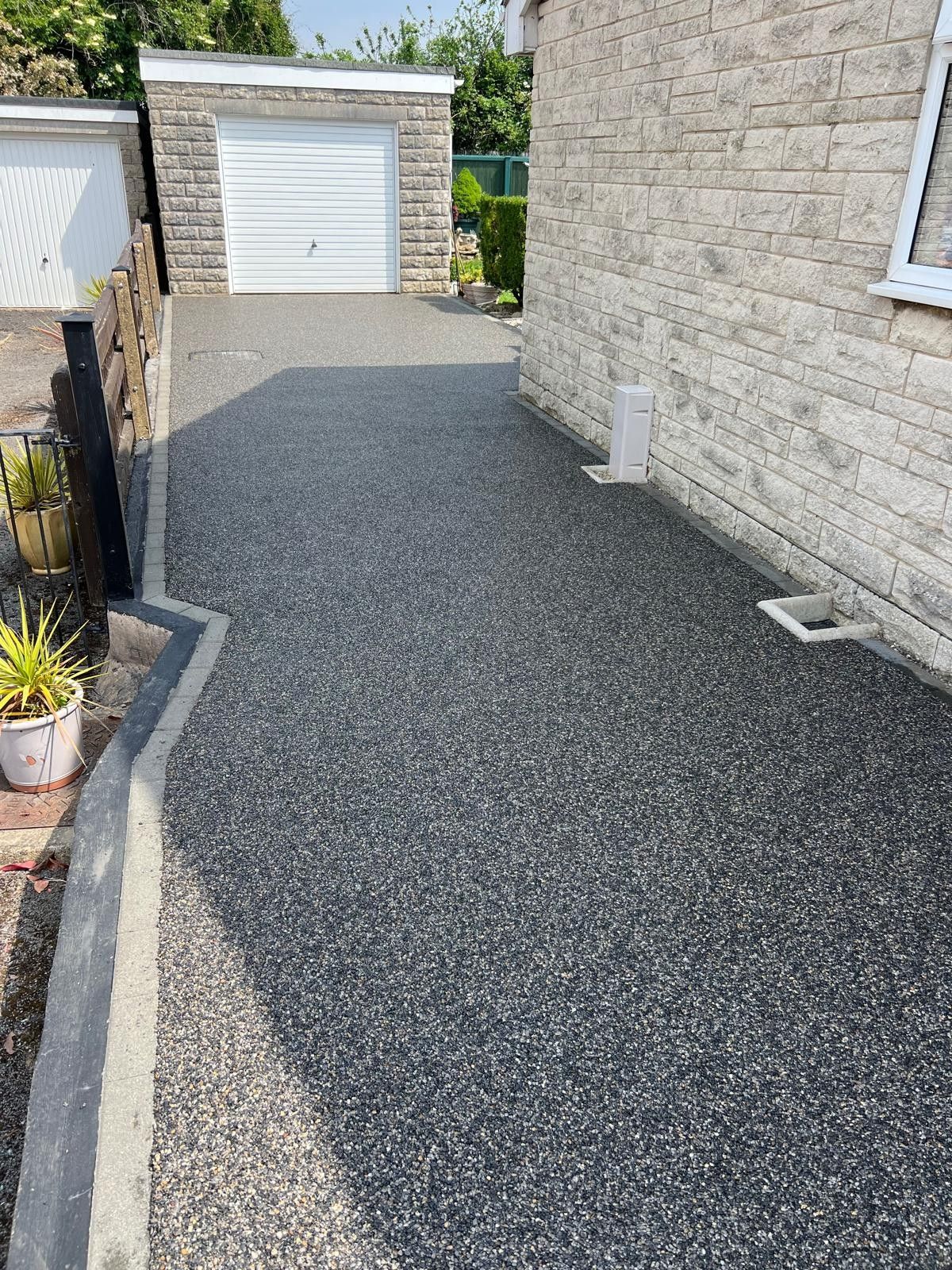 Charcoal resin bound driveway with a compass-rose inlay by Stoneage Property Care in Wiltshire